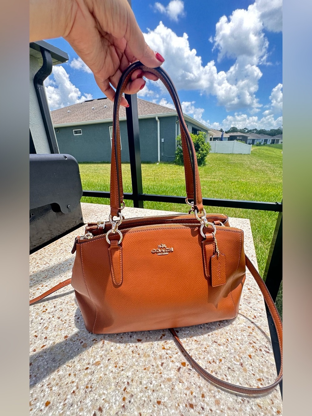 Coach Christie Carryall in a brown, textured leather with gold-tone hardware
